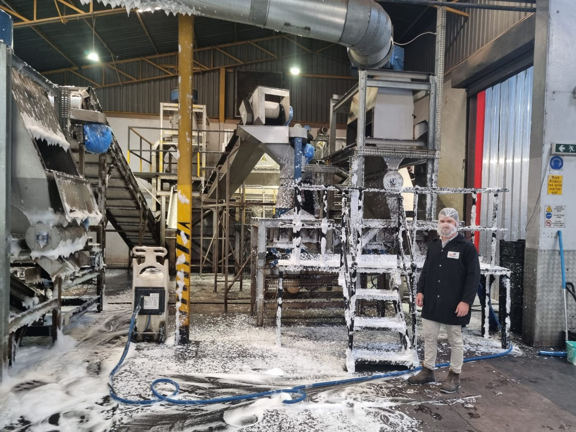 FactoryFresh team member beside production equipment during a facility clean